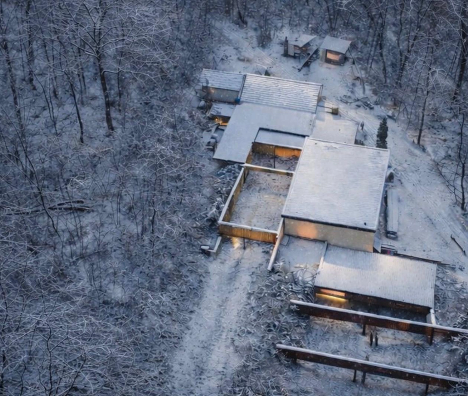 Schützenverein Bissingen/Enz e.V. – Eine Luftaufnahme von modernen, schneebedeckten Häusern, die in einem stillen, verschneiten Wald warm leuchten.