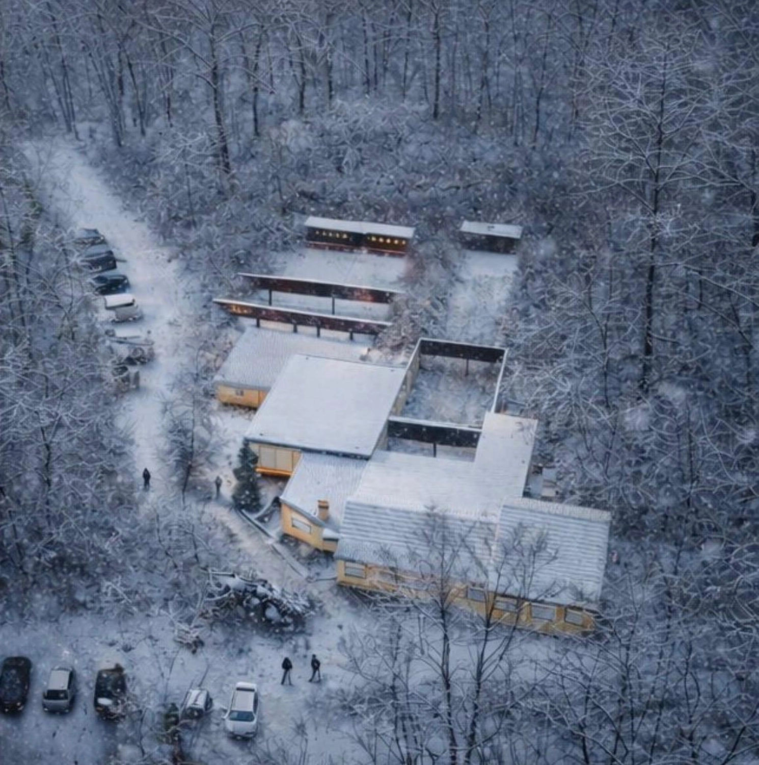 Schützenverein Bissingen/Enz e.V. – Eine Luftaufnahme von modernen, schneebedeckten Häusern, die in einem stillen, verschneiten Wald warm leuchten.