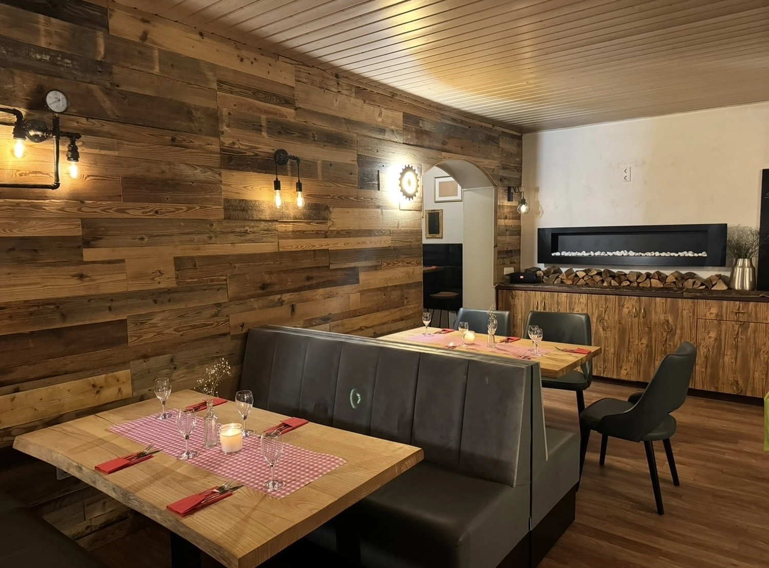 Schützenverein Bissingen/Enz e.V. – Ein gemütliches Restaurantinterieur mit Holztischen, schwarzen Stühlen, warmer Beleuchtung und rustikalem Dekor.
